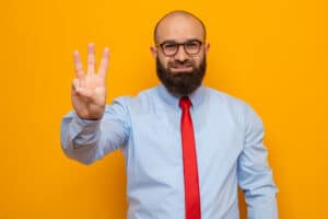 a man with a beard and glasses making the vulcan sign