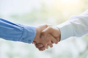 two people shaking hands over each other